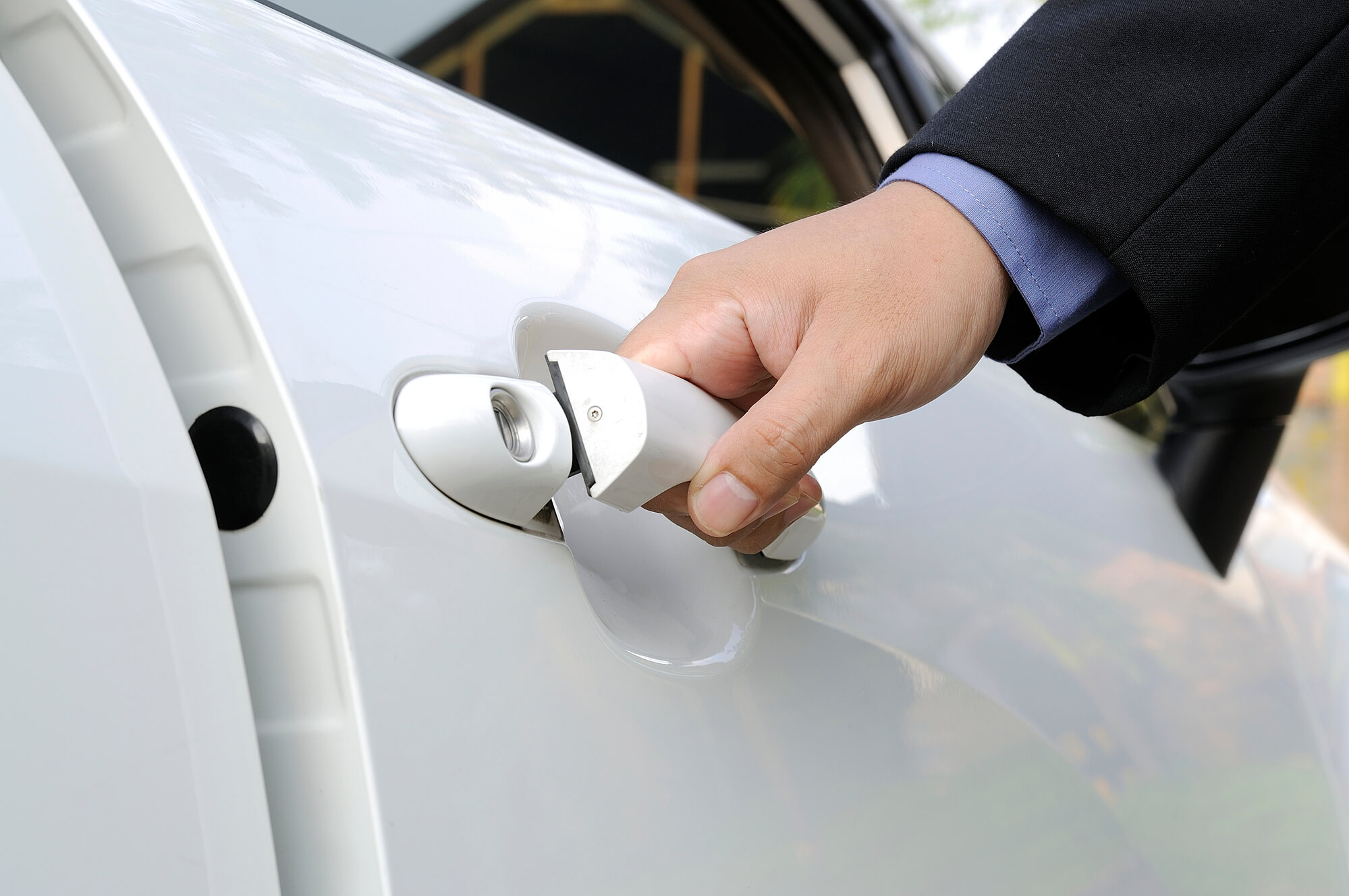 Valet attendant opening the door of a luxury car